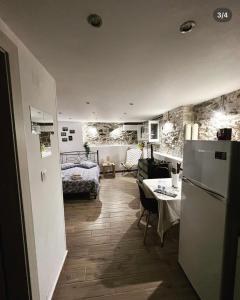 a kitchen and living room with a refrigerator and a table at Sofisstudios in Mytilene