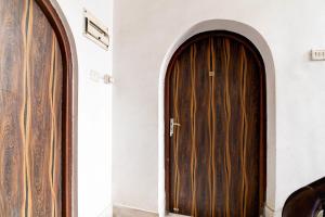 two large wooden doors in a white wall at Hotel O Avenue Villa in Dum Dum