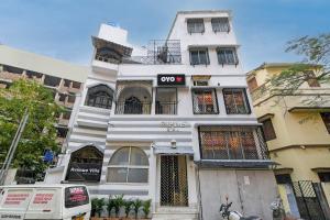 a white building with a sign on it at Hotel O Avenue Villa in Dum Dum +4 photos