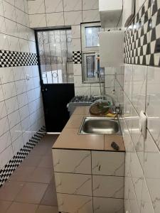a small kitchen with a sink and a window at Janamaev in Yaoundé +28 photos