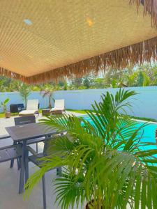 a patio with a table and chairs and a pool at Villa l'Aurora in Amphoe Koh Samui