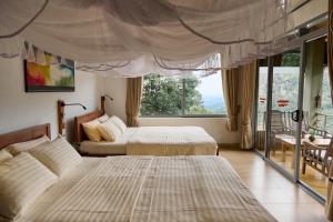 Un dormitorio con dos camas y una gran ventana. en Zion View Ella Green Retreat, en Ella 139 fotos más
