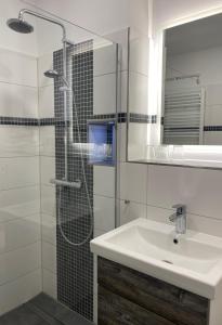 a white bathroom with a sink and a shower at Ferienhaus "Am Papststein" in Papstdorf
