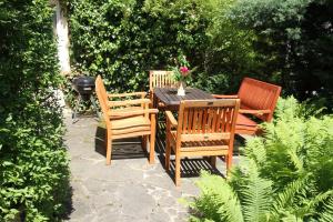 a wooden table with four chairs and a grill at Ferienhaus "Am Papststein" in Papstdorf