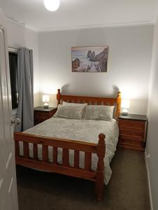a bedroom with a wooden bed with two night stands at Ocean views in Portland