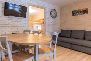 a living room with a table and a couch at Apartamenty przy winnicach - blisko term - świetny wybór dla rodzin z dziećmi - mówimy po polsku! in Bogács