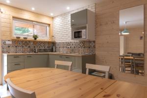 a kitchen and dining room with a wooden table and chairs at Apartamenty przy winnicach - blisko term - świetny wybór dla rodzin z dziećmi - mówimy po polsku! in Bogács