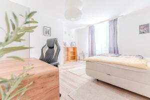 多瑙河畔克雷姆斯Central apartment by Train Station Krems的一间卧室，配有一张床和一张带椅子的书桌 更多19张照片