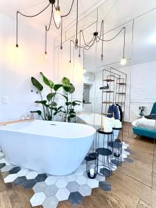 Un baño con una gran bañera blanca y un dormitorio. en Warszawa Centrum Designerski Apartament z Wanną, en Varsovia