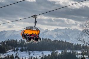 a group of people riding on a ski lift at DWOREK MYŚLIWSKI HUBERT-Tutaj czeka na ciebie oszczędność & komfort & najlepsza lokalizacja, Jesteśmy przy samych Termach Bania i Stoku Narciarskiego Kotelnica, Na miejscu wypożyczalnia nart, rowerów w atrakcyjnej cenie dla gości oraz darmowy parking in Białka Tatrzańska