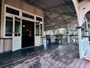 an open porch of a building with a table and chairs at Kilkivan Homestead in Kilkivan