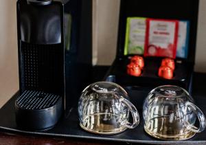 ein schwarzer Tisch mit zwei silbernen Tellern und einem Mixer in der Unterkunft Monte Pacis Hotel In Pažaislis in Kaunas