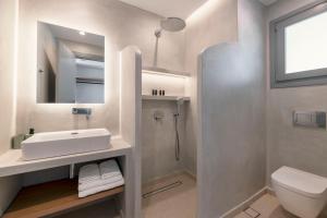 a bathroom with a sink and a toilet and a mirror at La Maltese Central in Naousa +20 photos