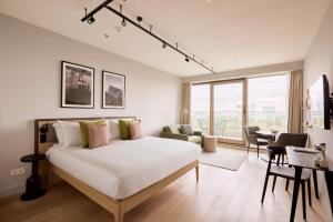 une chambre blanche avec un lit et un salon dans l'établissement Wilde Aparthotels Amsterdam Noord, à Amsterdam