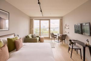 un salon avec un lit, une table et des chaises dans l'établissement Wilde Aparthotels Amsterdam Noord, à Amsterdam