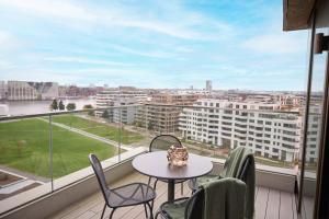 un balcon avec une table et des chaises et une grande fenêtre dans l'établissement Wilde Aparthotels Amsterdam Noord, à Amsterdam