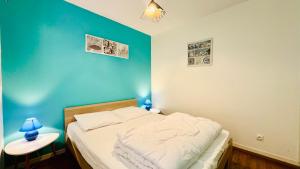a bedroom with a bed with a blue wall at L'air de Stella-Plage au coeur de la Station Balnéaire in Stella-Plage