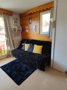 a black couch in a room with a window at véritable 2 pièces, vue panoramique in Allos