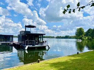 a boat parked at a dock on a lake at Houseboat Marina Mookerplas 4-6 persoons (met hottub en dakterras) in Middelaar