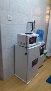a kitchen with a microwave on top of a refrigerator at HERIJ Staycation kitengela in Kitengela  +8 photos