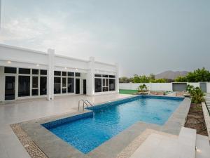 a swimming pool in the backyard of a house at Al-Salam Villa-Family Pool & Private Garden in Misfāh