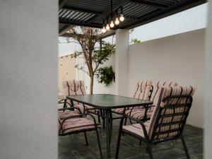 a patio with a table and chairs and a tree at Al-Salam Villa-Family Pool & Private Garden in Misfāh