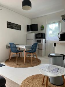 ein Wohnzimmer mit einem Tisch und zwei Stühlen in der Unterkunft Appartement T2, très bien équipé, avec terrasse, jardin, et accès piscine in Cambo-les-Bains