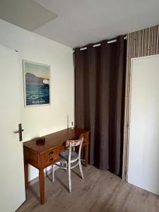 Zimmer mit einem Schreibtisch und einem Kreuz an der Wand in der Unterkunft Appartement T2, très bien équipé, avec terrasse, jardin, et accès piscine in Cambo-les-Bains + 20 Fotos