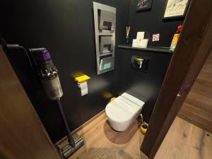 a bathroom with a white toilet in a black wall at Immodelpas Pic Blanc in Pas de la Casa +16 photos