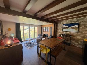 a living room with a wooden table and a brick wall at Immodelpas Pic Blanc in Pas de la Casa