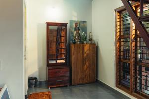 a room with a wooden cabinet and a mirror at Coorg Saturn Homes in Madikeri