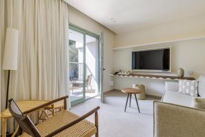 スコペロスにあるMinnŏ Boutique Hotel & Spaのリビングルーム(テレビ、ソファ、テーブル付)