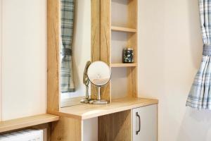 Un vestidor con un espejo sobre una estantería de madera en Squirrel Lodge with Hot Tub, en Pocklington 22 fotos más