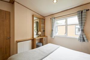 un dormitorio con una cama y una ventana en Squirrel Lodge with Hot Tub, en Pocklington