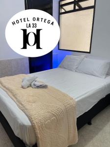 un lit avec une couverture dessus portant l'inscription « officier d'hôtel » dans l'établissement hotel ortega la 33, à Medellín