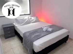 une chambre avec un lit avec un animal en peluche dessus dans l'établissement hotel ortega la 33, à Medellín