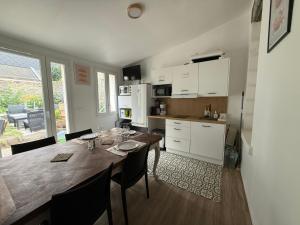 a kitchen and dining room with a wooden table with chairs at Bastide Collection in Cherbourg en Cotentin