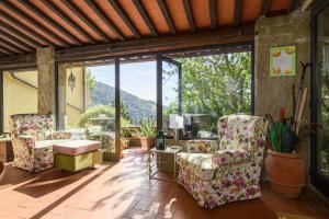 a living room with chairs and a large window at Il Palazzaccio - Tuscan Historical Villa in Reggello in Reggello