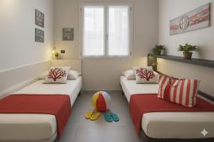 two beds in a room with a volley ball on the floor at Il Sole Di Bruno in Imperia