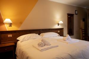 a bedroom with a bed with towels on it at Hotel Chalet Seggiovia in Pontechianale