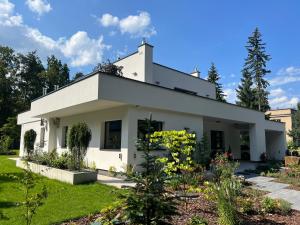 une maison blanche avec un jardin dans l'établissement Modern Villa Located in the Heart of Konstancin-Jeziorna, à Konstancin-Jeziorna