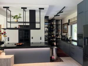 une cuisine avec des armoires noires et un comptoir dans l'établissement Modern Villa Located in the Heart of Konstancin-Jeziorna, à Konstancin-Jeziorna