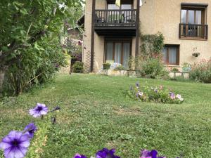 une cour avec des fleurs violettes devant une maison dans l'établissement Charmant 2 pièces avec parking et Wi-Fi à Saint-Chaffrey - FR-1-762-46, à Saint-Chaffrey 3 autres photos