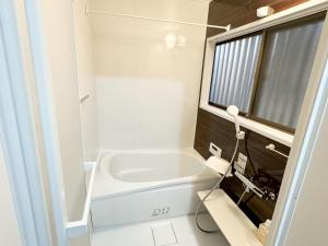 a white bathroom with a tub and a sink at Ai dear KAWAGOE in Kawagoe +23 photos