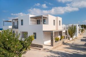 a white house on the side of a road at La Maltese Central in Naousa