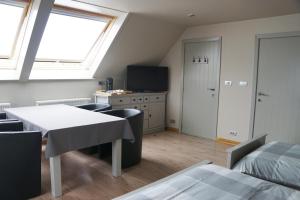 een kamer met een tafel en stoelen en een raam bij B&B The Beachhouse in Oostduinkerke