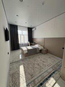 a bedroom with a bed and a desk in it at Отель Жанатас in Zhangatas