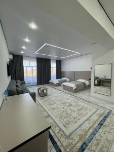 a large room with two beds and a living room at Отель Жанатас in Zhangatas