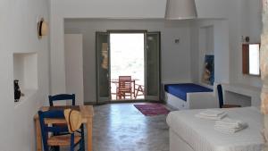 a room with a bed and a table and chairs at Dimitra Studios in Aegiali