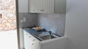 a kitchen with a sink and a bowl of fruit at Dimitra Studios in Aegiali